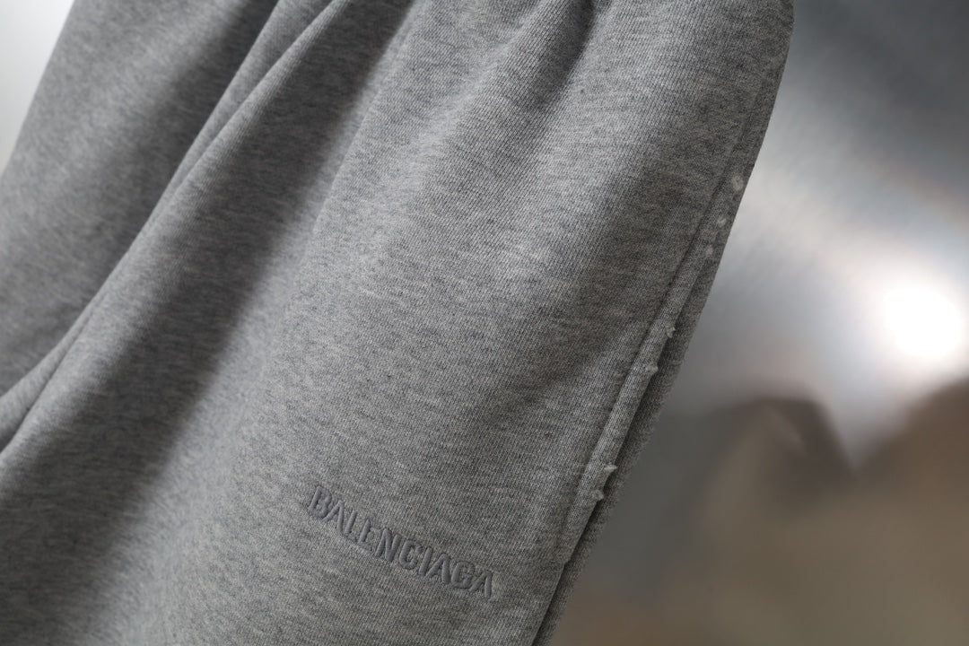 Gray shorts with BALENCIAGA logo near hem on one leg