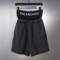 Black Balenciaga shorts with elastic waistband and front pleats, hanging on a hanger