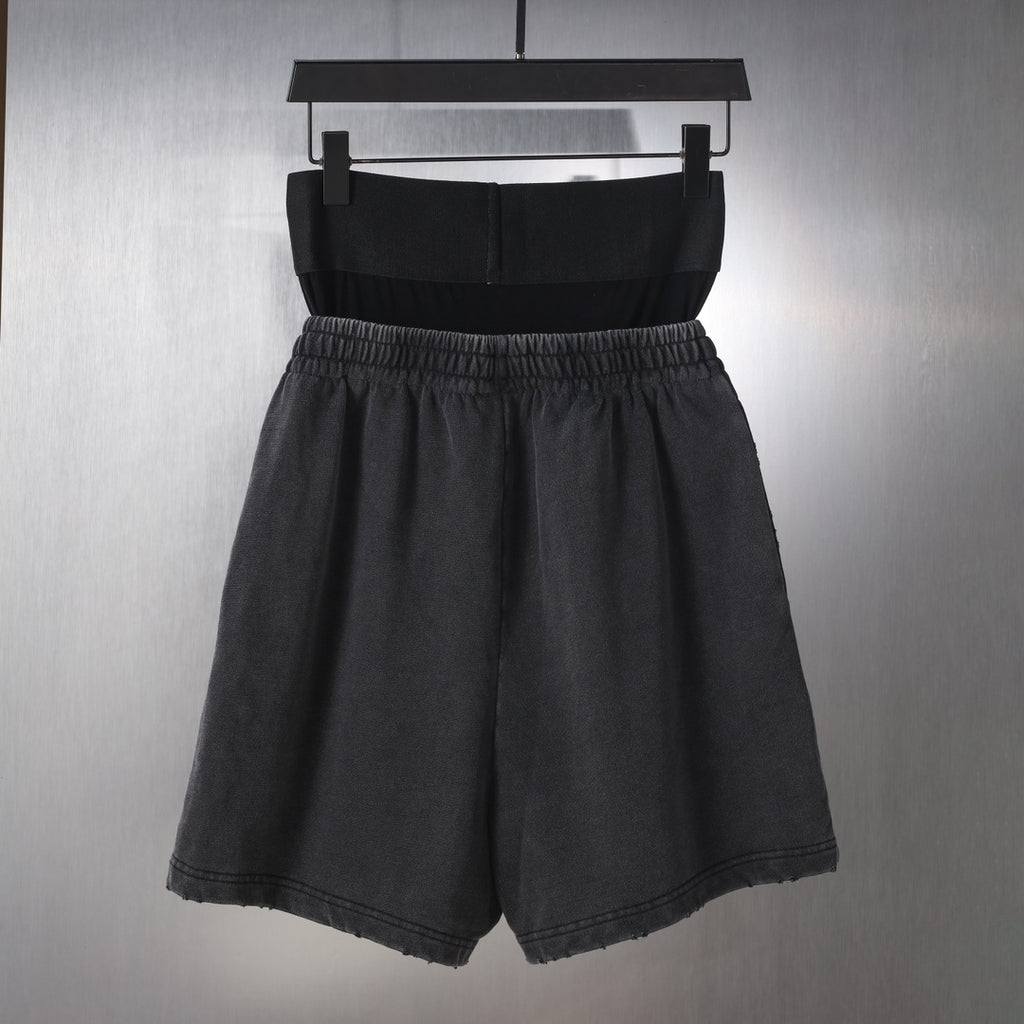 Black Balenciaga shorts with elastic waistband and relaxed fit, front view on hanger