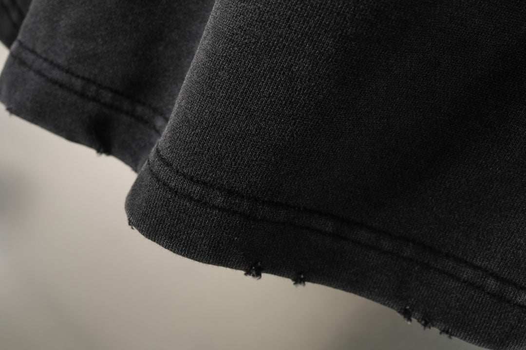 Black Balenciaga shorts hem with slightly frayed edge, close-up