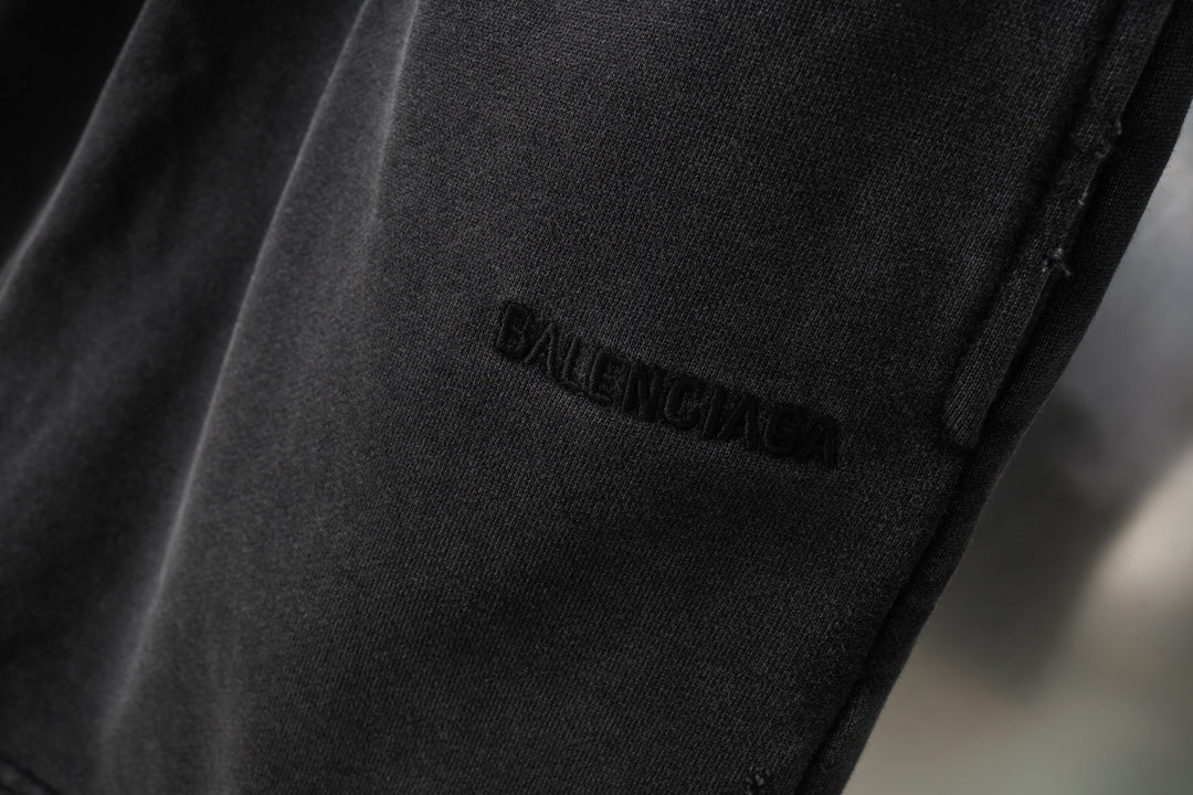 Black Balenciaga shorts leg with small stitched logo near hem, close-up