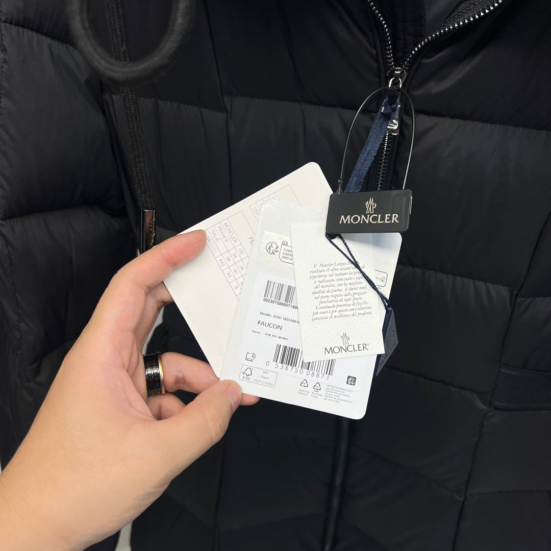 Clothing tags attached to a dark quilted puffer coat with zipper