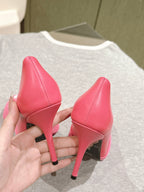 Pink heeled sandals viewed from side with pointed toe and black insole