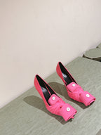 Pink sandals with knotted front straps and black lining, placed side by side
