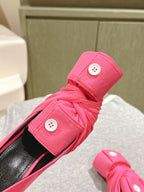 Pink sandal close-up showing knotted strap with button hardware and black footbed