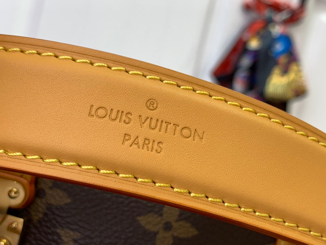Louis Vuitton bag close-up of tan leather trim with stitched edge and brand text