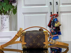 Louis Vuitton crossbody bag showing tan strap and top handle over dark monogram canvas