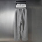 Grey Balenciaga sweatpants with elastic waistband and wide legs, distressed knee hems