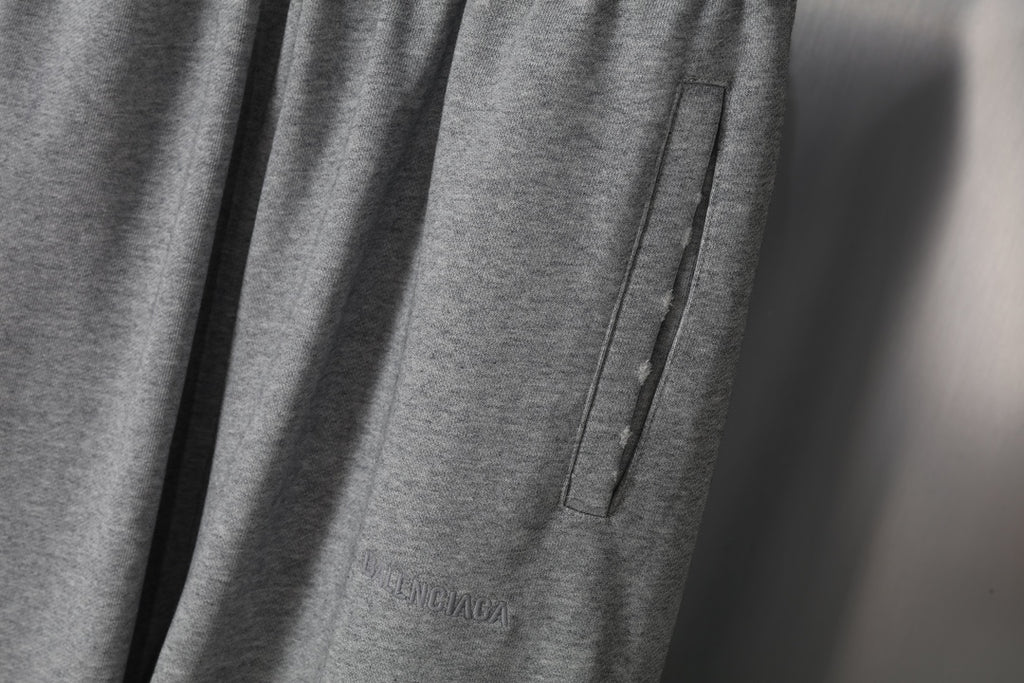 Grey sweatpants side seam detail with pocket-like panel and stitched edge