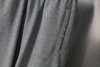Grey sweatpants side seam detail with pocket-like panel and stitched edge