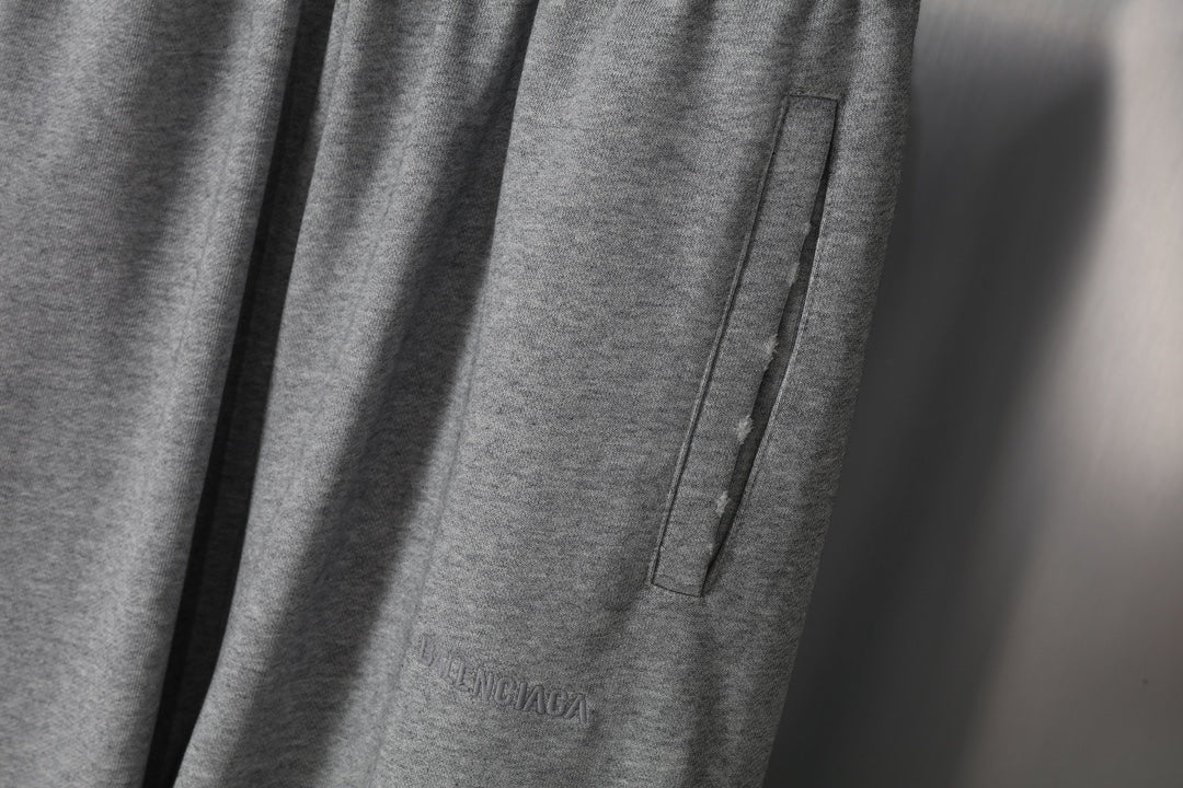 Grey sweatpants side seam detail with pocket-like panel and stitched edge