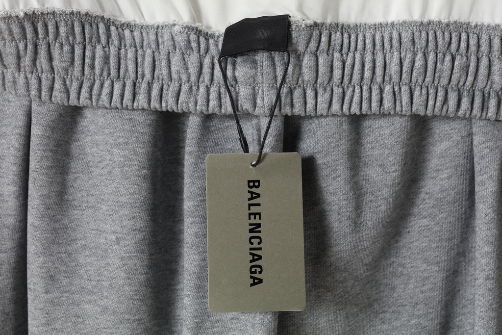 Heather gray pants with elastic waistband and dangling BALENCIAGA brand tag