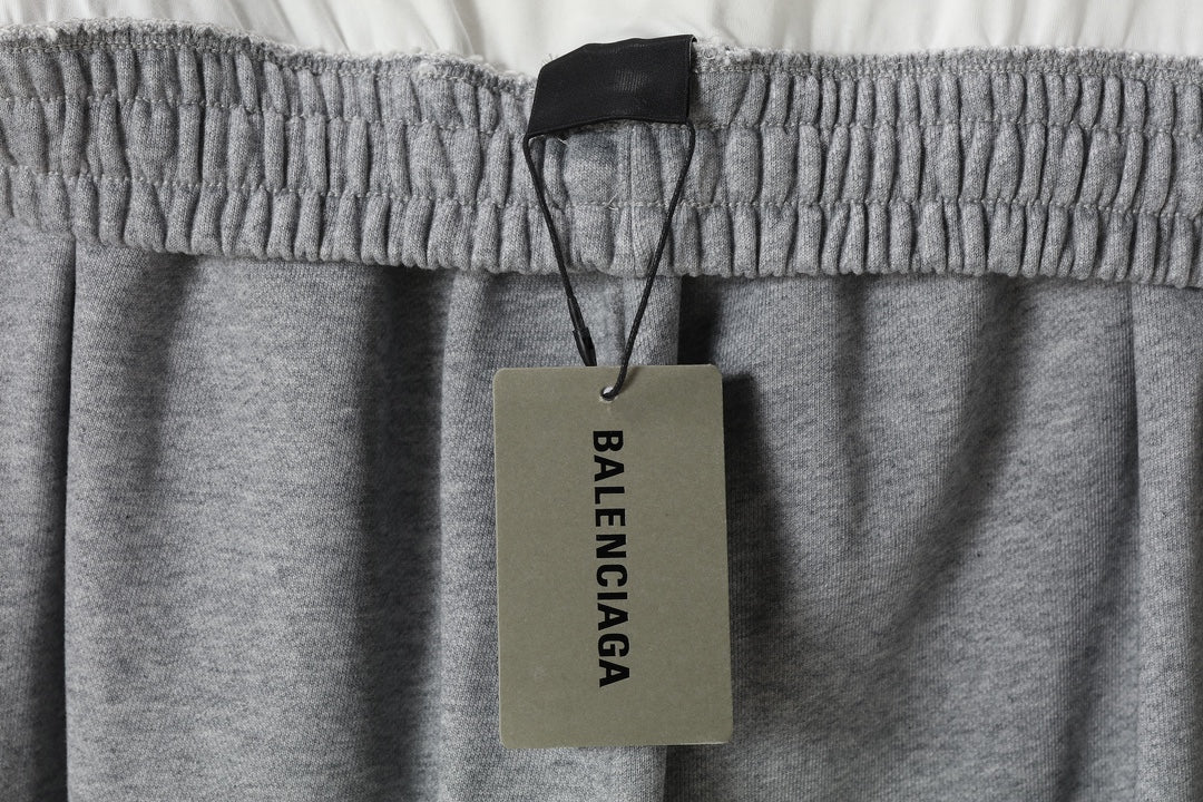 Heather gray pants with elastic waistband and dangling BALENCIAGA brand tag
