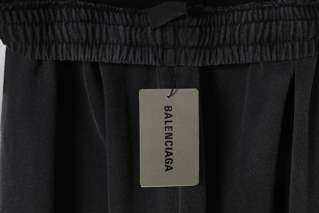 Black pants with hanging fabric tag on the elastic waistband