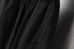 Black pants with vertical pocket and small logo print