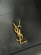 YSL logo emblem in gold on dark navy leather with diamond quilting