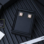 Square Chanel logo stud earrings with pink enamel center and gold-tone frame