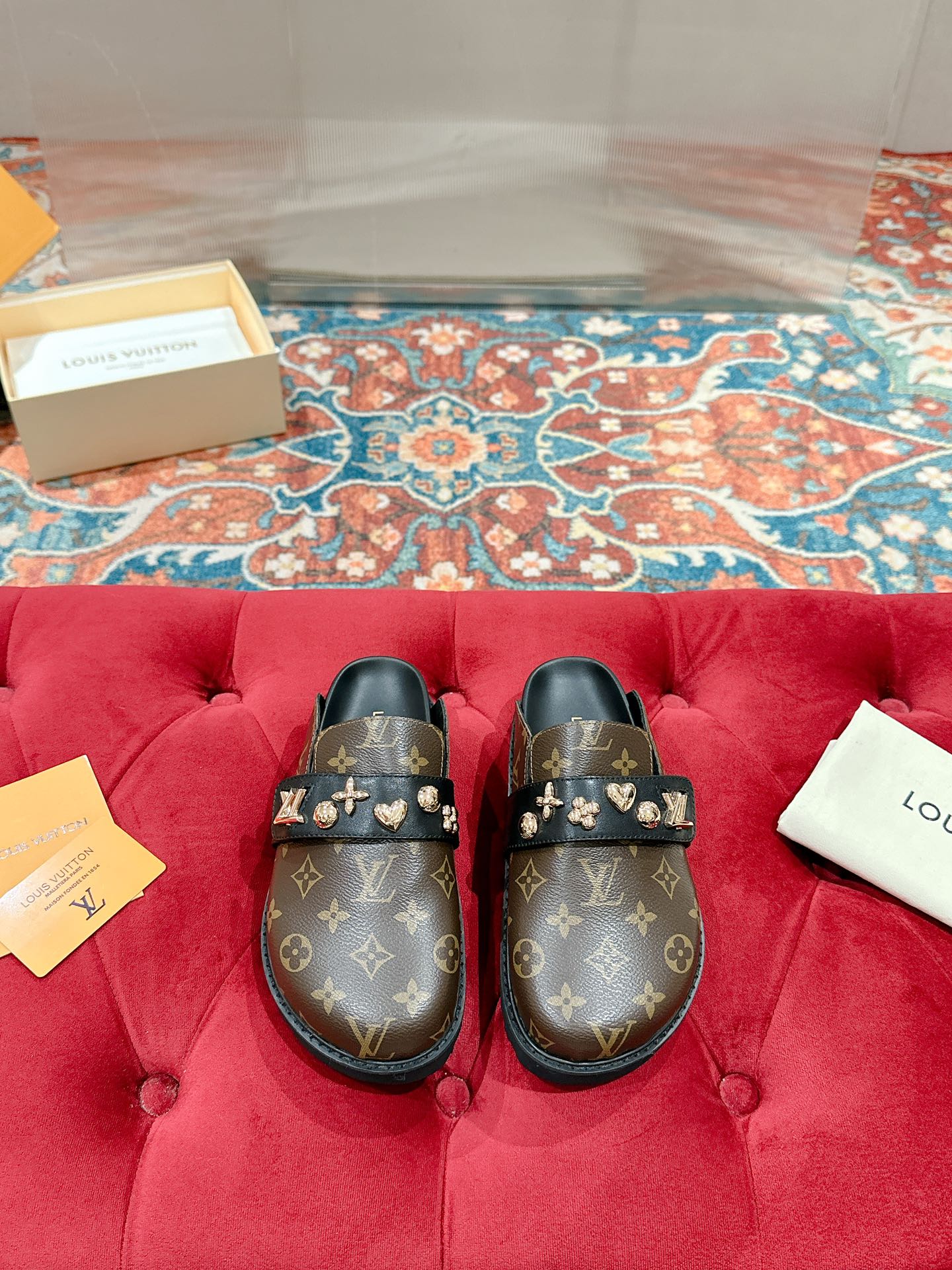 Louis Vuitton monogram slide sandals with gold-tone emblem buckles, black.
