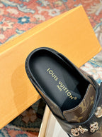 Louis Vuitton monogram slide sandal with black leather lining and gold-tone hardware.
