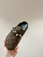 Louis Vuitton monogram slide sandal, black upper with gold-tone hardware accents.