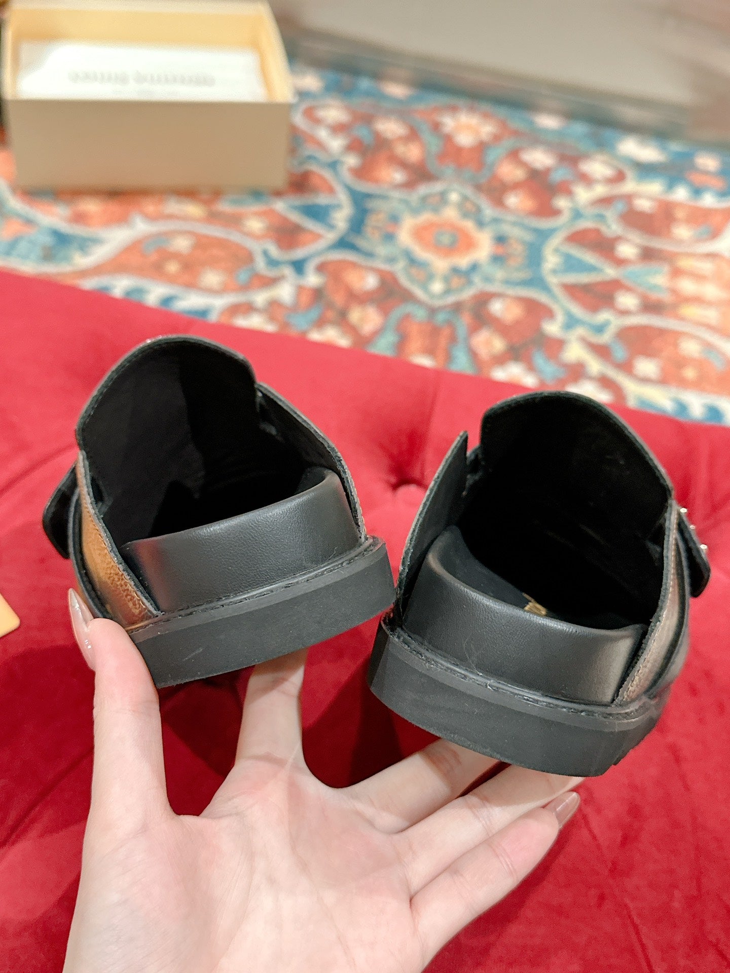 Louis Vuitton slide sandals, underside view showing black straps and footbed.