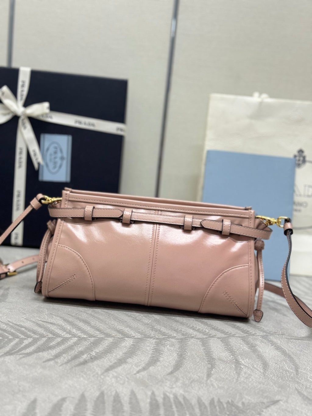Pink leather satchel with braided top strap, gold-tone zipper, and shoulder strap