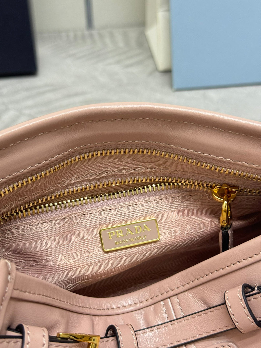 Pink leather bag interior with Prada logo label and twin gold-tone zipper tracks