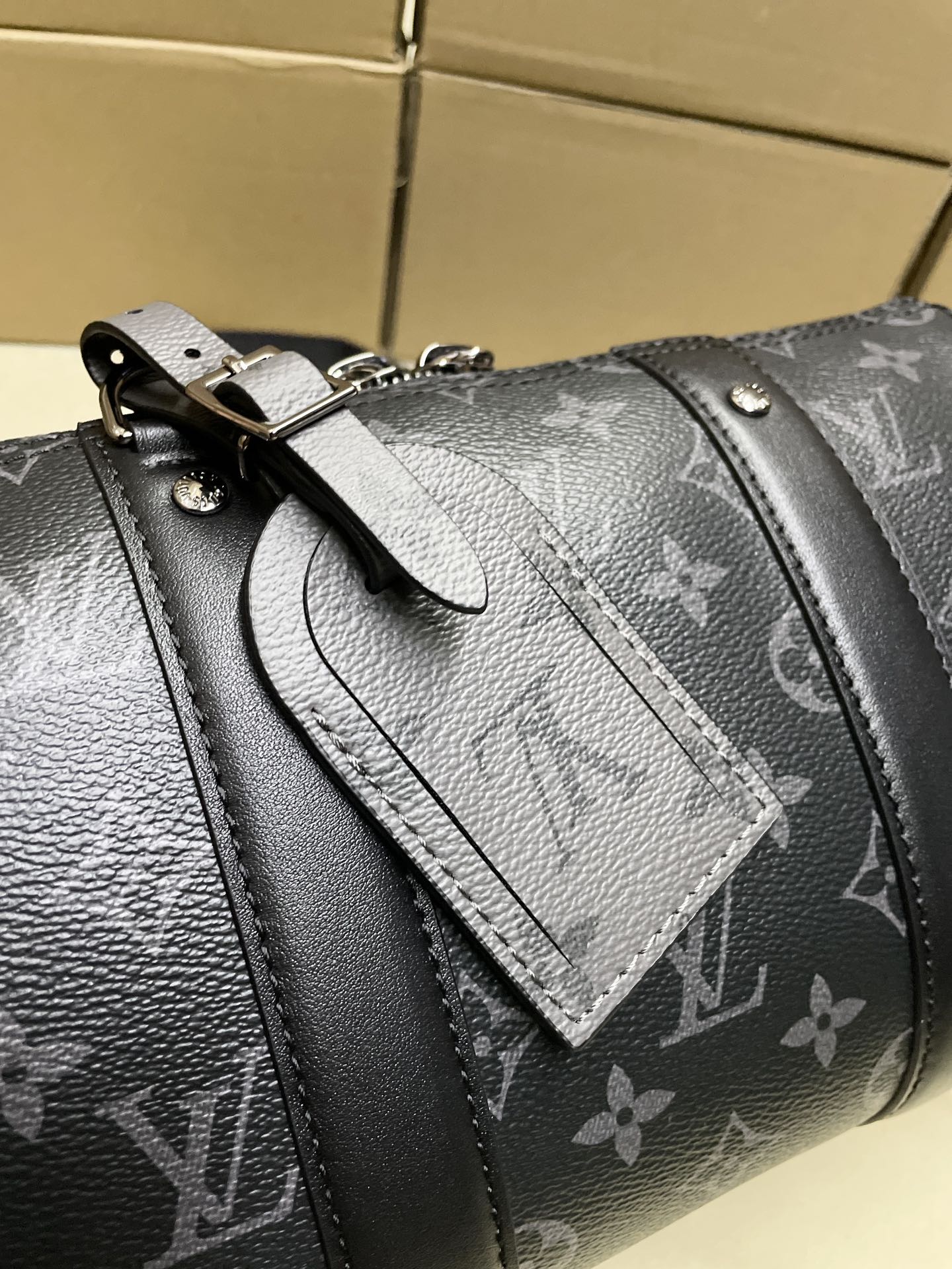 Monogram canvas bag close-up of strap and decorative leather panel