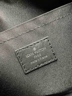Leather brand label reading Louis Vuitton on monogram canvas bag