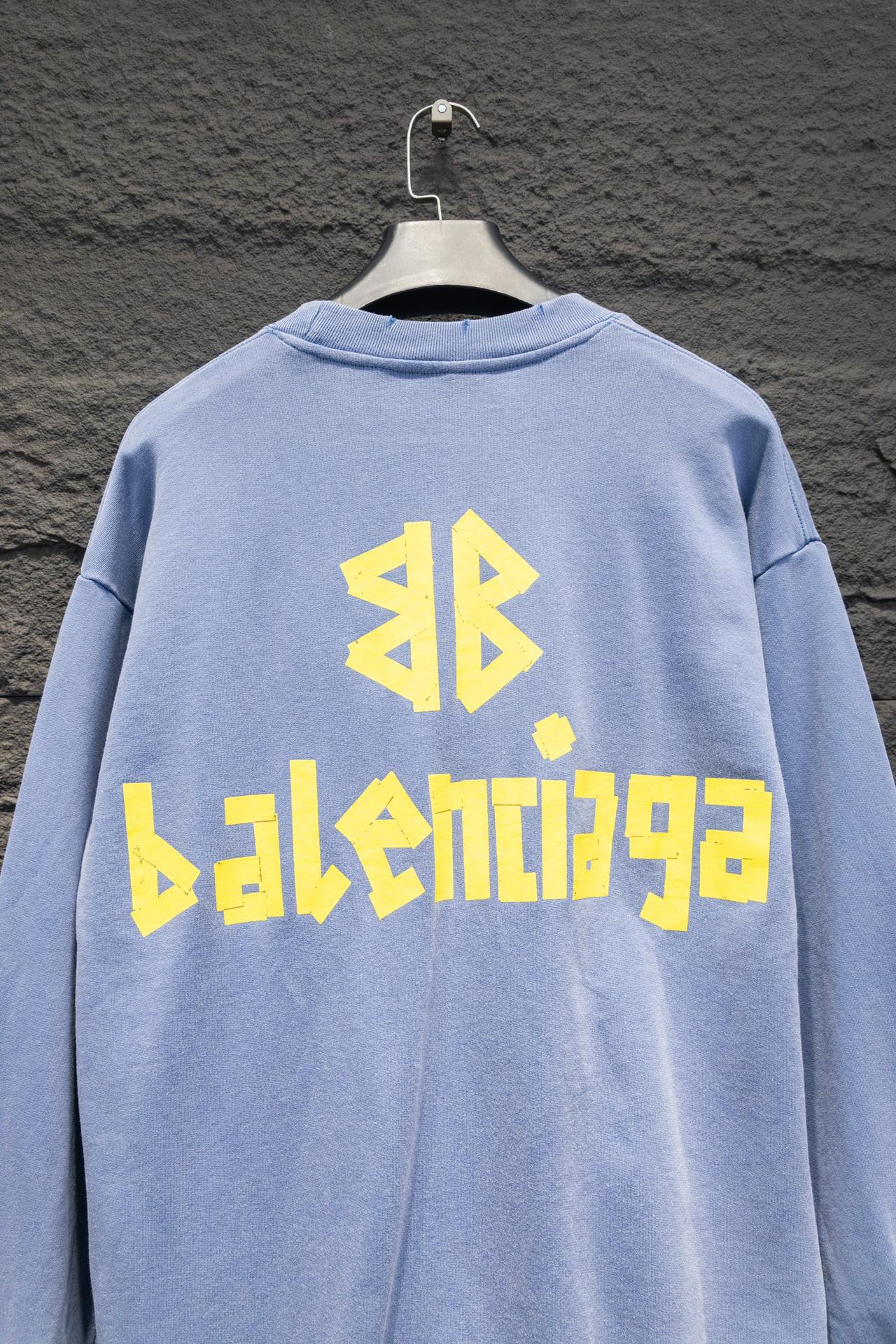 Light blue sweatshirt back view, crewneck, long sleeves, Balenciaga logo graphic.