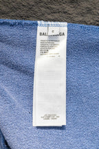 Blue sweatshirt interior label tag on fabric near the waistband.