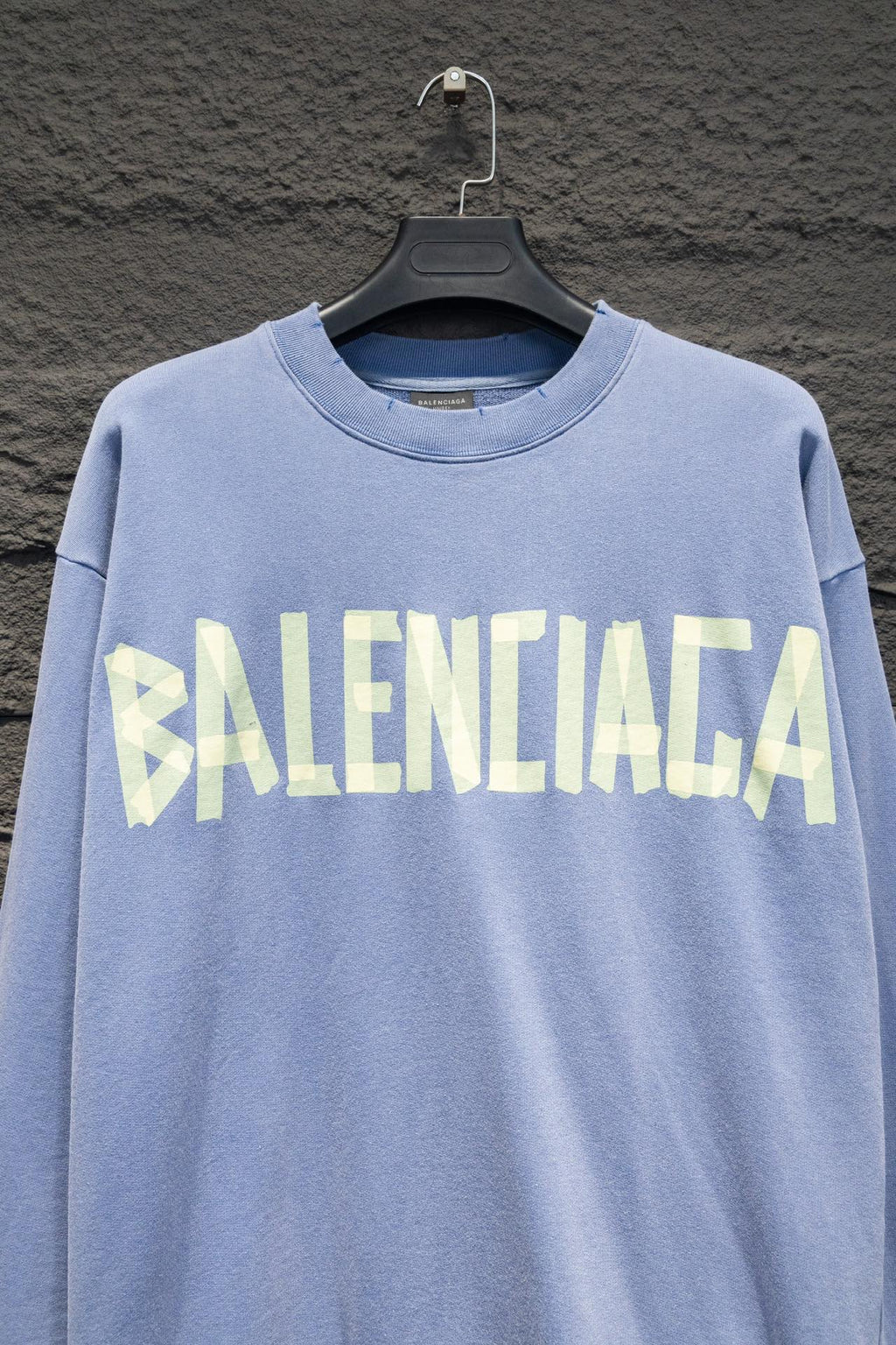 Light blue sweatshirt with crewneck and Balenciaga logo across the chest.