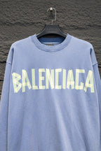 Light blue sweatshirt with crewneck and Balenciaga logo across the chest.