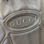 Gucci embossed logo oval patch on dark gray backpack panel