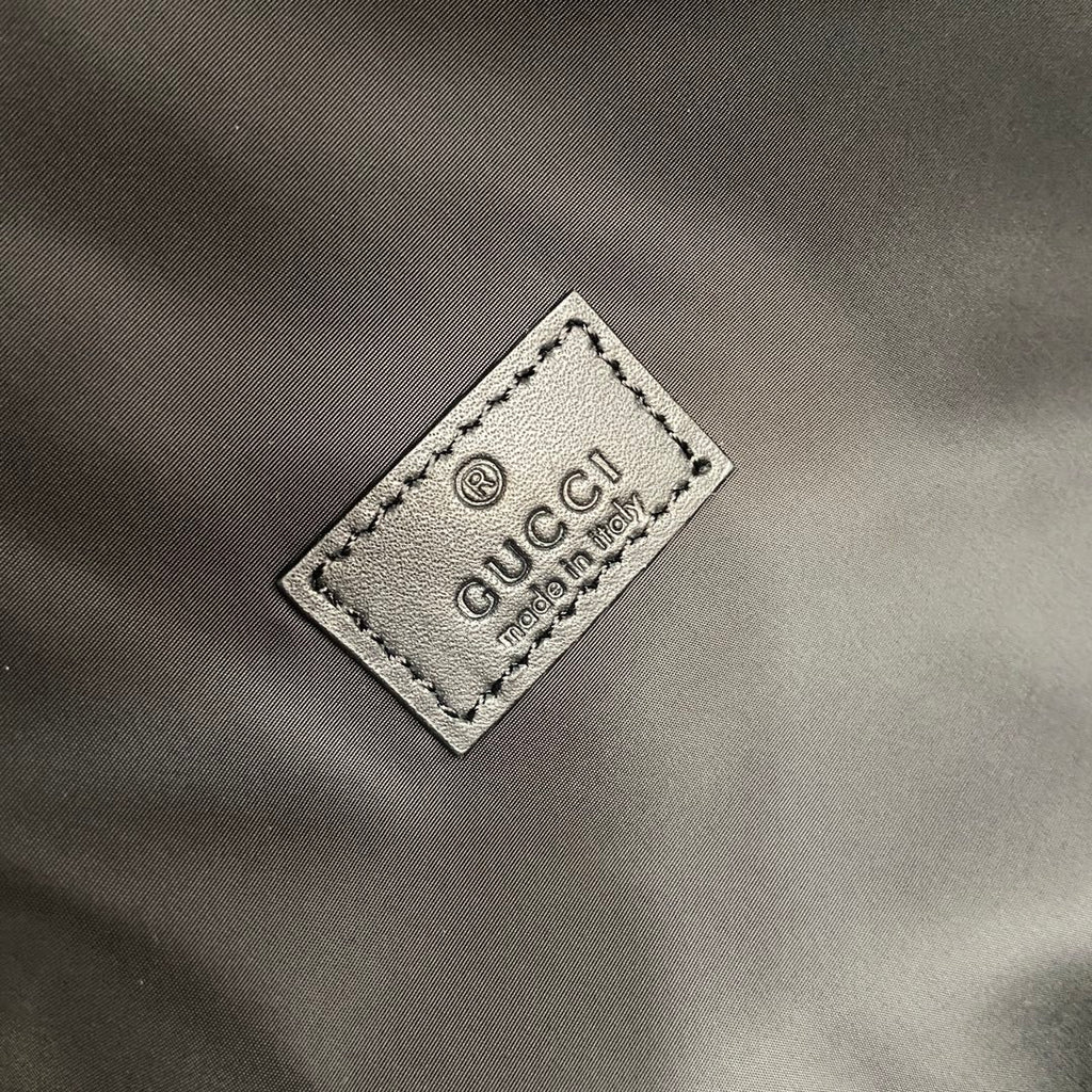 Gucci logo label patch on gray backpack interior with white printed text