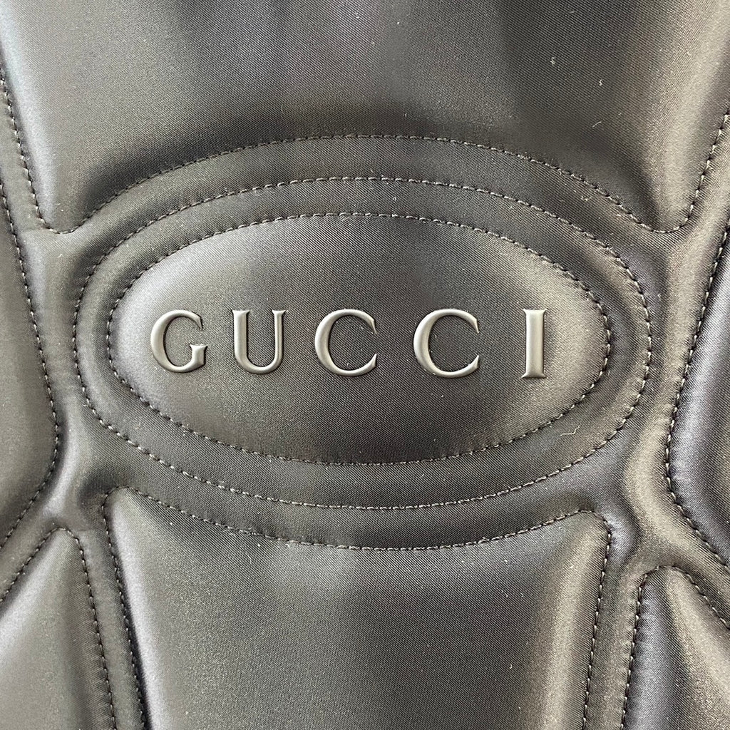 Gucci logo oval on black leather backpack front with stitched edging