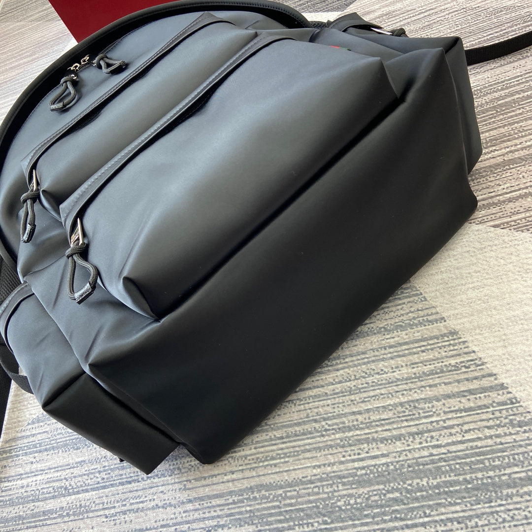 Gucci black backpack side view with exterior zip pocket and leather handle