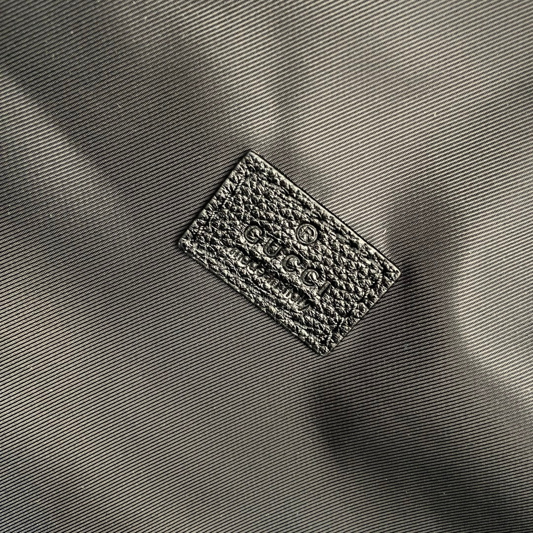 Gucci woven fabric label on black backpack interior