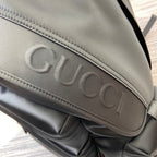 Gucci embossed lettering on black backpack flap with stitched border