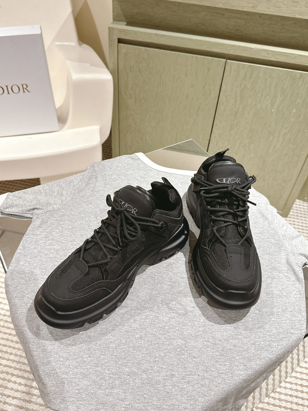 Dior unisex black sneakers on a display, lace-up with textured toe cap