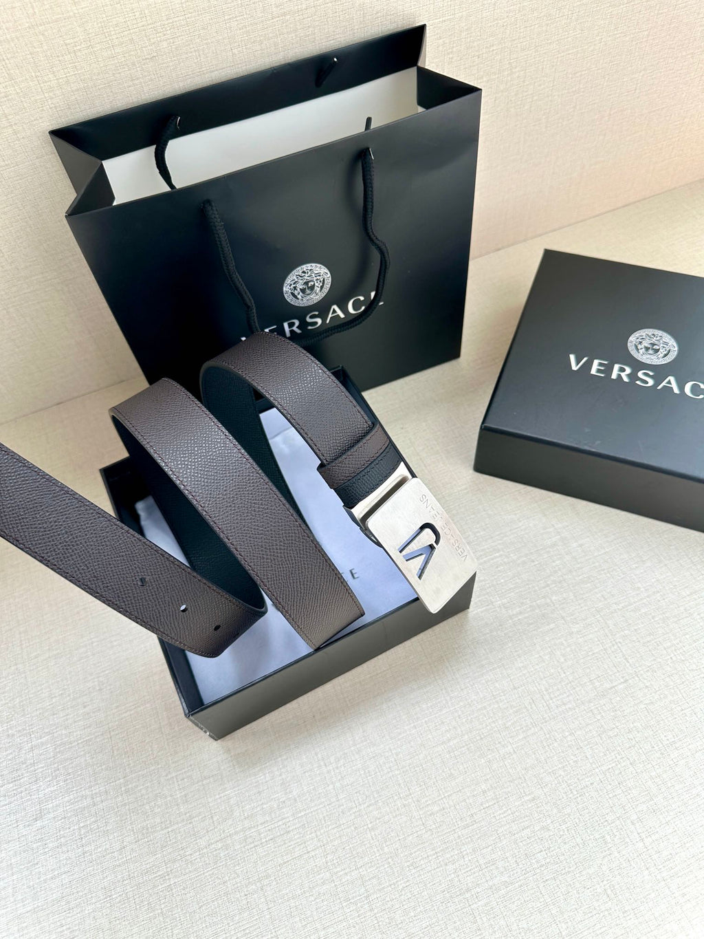 Leather belt with dark strap and white buckle plate with VJ logo