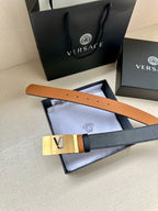 Versace belt with dark leather strap, tan underside, gold buckle and punched holes.