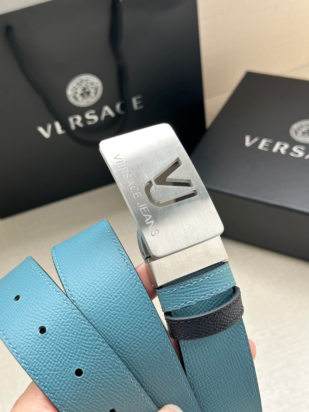 Silver belt buckle with VJ engraving on turquoise pebbled leather strap with holes