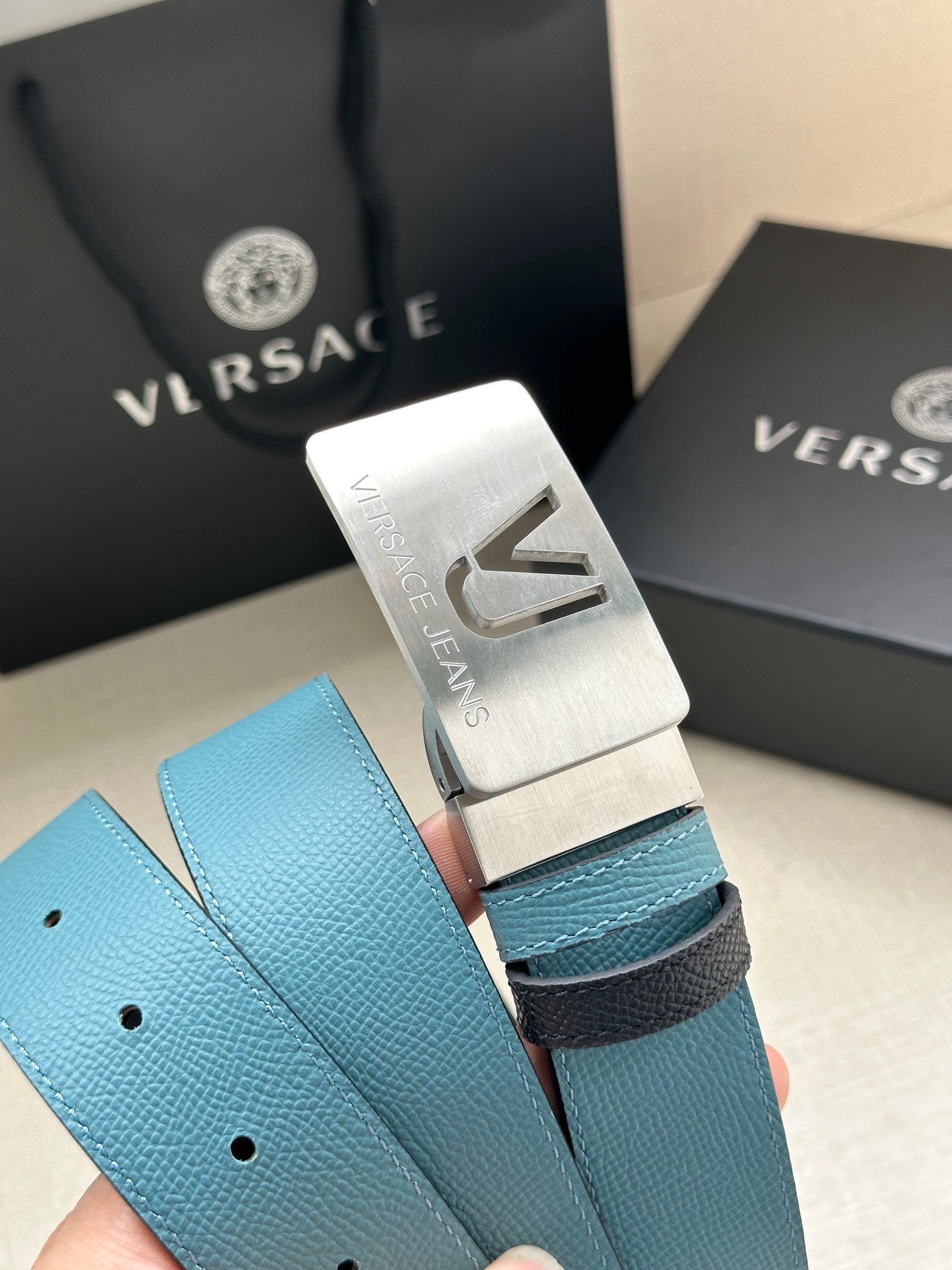 Silver belt buckle with VJ engraving on turquoise pebbled leather strap with holes