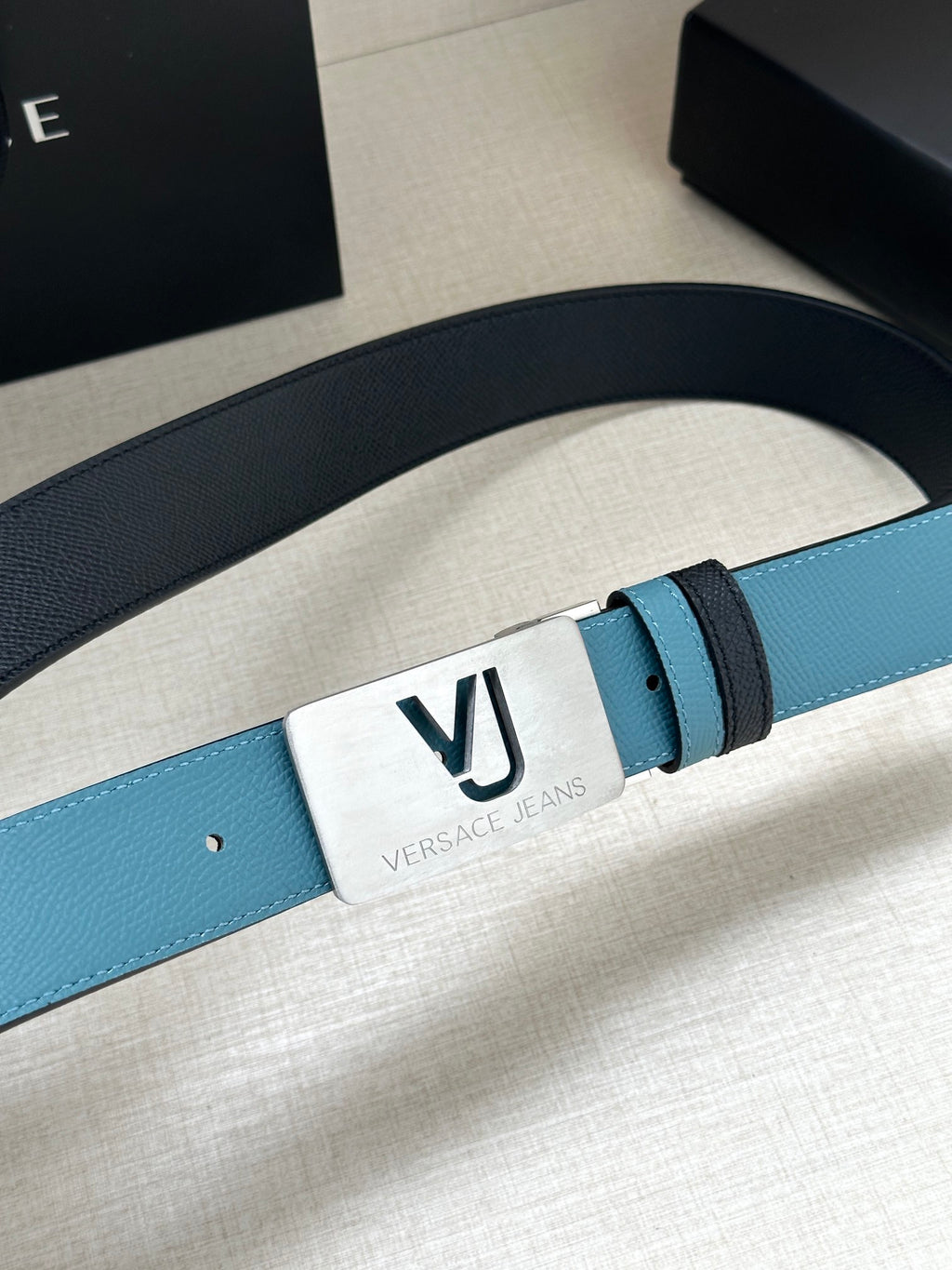Two-tone leather belt with turquoise strap and silver square VJ logo buckle
