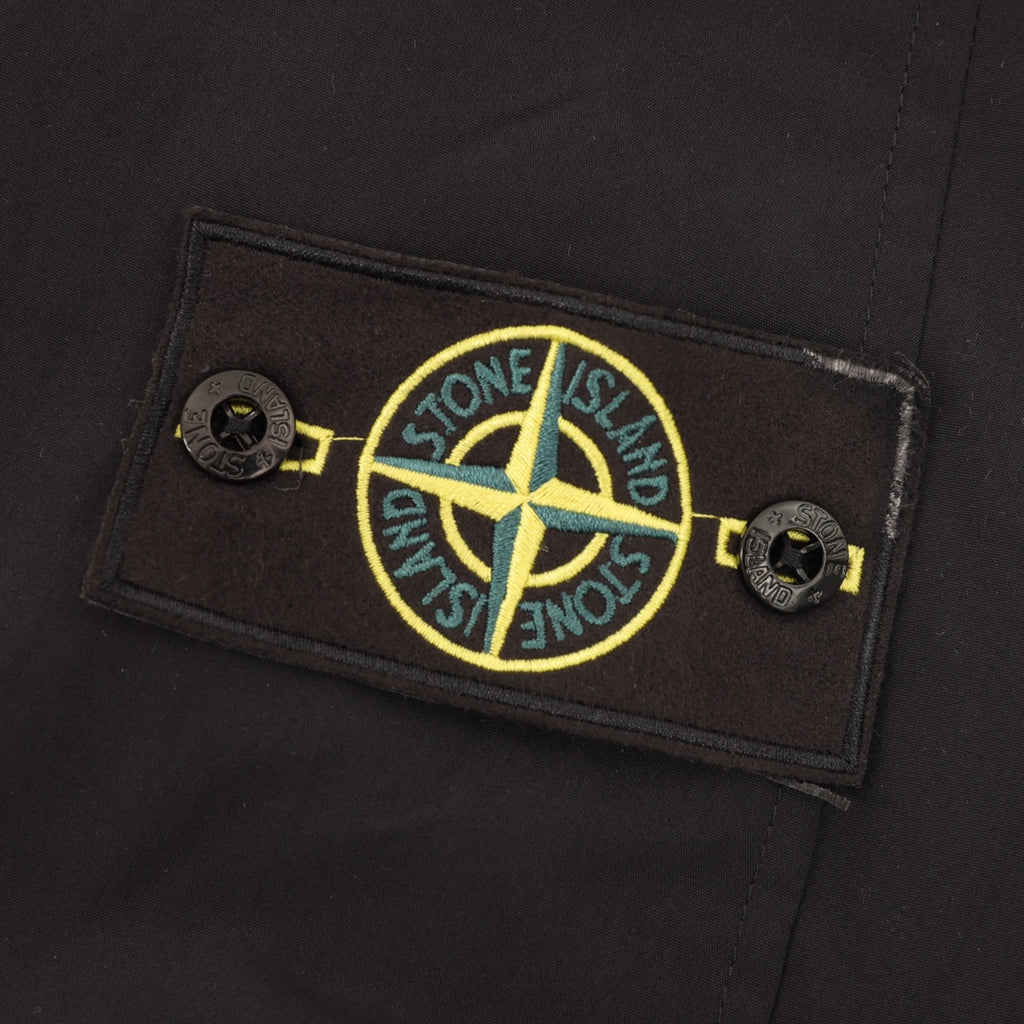 Stone Island jacket logo patch with yellow and blue emblem on black