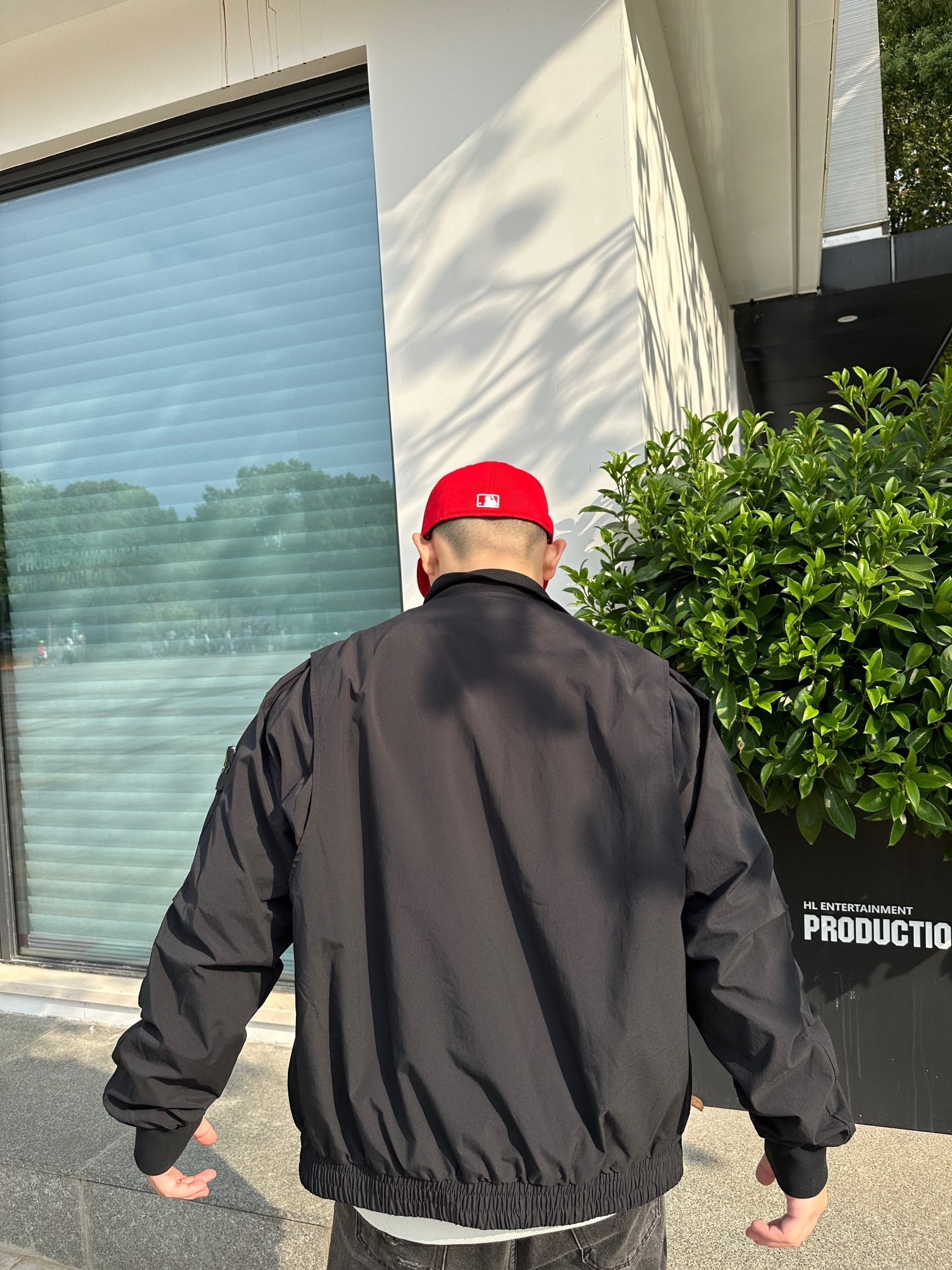 Back view of a black jacket with stand collar and ribbed hem