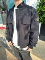 Black jacket detail with chest flap pocket and logo patch on sleeve