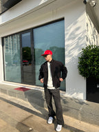 Black jacket with stand collar and front pockets, worn over a white T-shirt