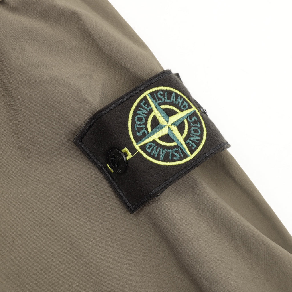 Stone Island sleeve logo patch on olive bomber jacket